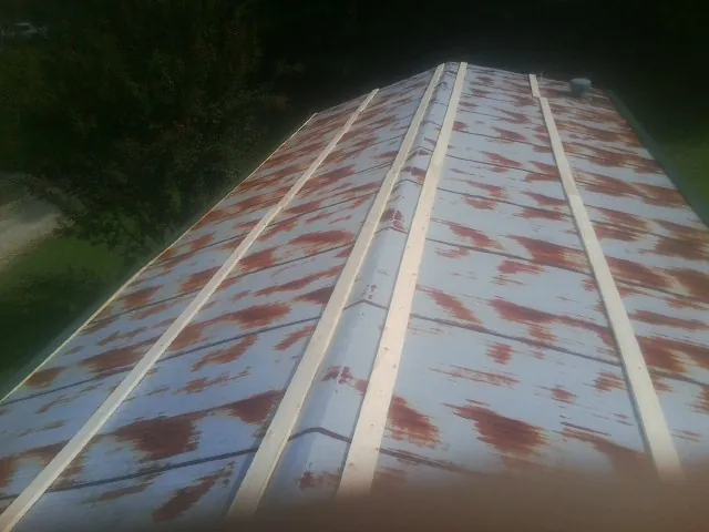 Rusted metal roof panels with new wood purlins before replacement — Storm Damage Roof Repair in Tingley by Roofing Brothers