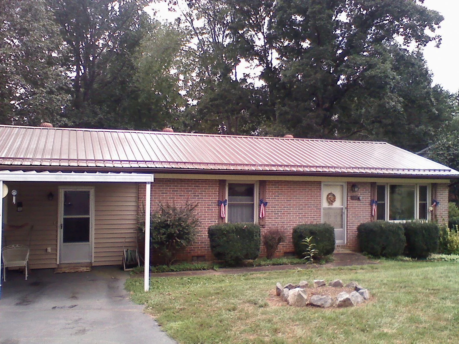 Bronze metal roof and carport on a brick ranch home — Roof Repair work by our crew in Tingley